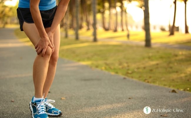 Bacak ağrısı olan kadın bir sporcu dizini tutuyor.