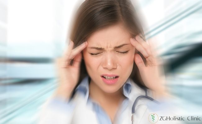 Migren hastası bir kadın kafasını tutuyor